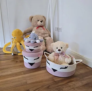 Ein Korb mit einer Decke und einem Quastel, dekorativ angeordnet.