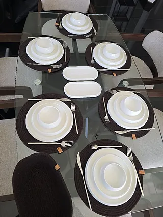 Ein geflochtener Korb, gefüllt mit einer bunten Decke und einem fransigen Quastel.